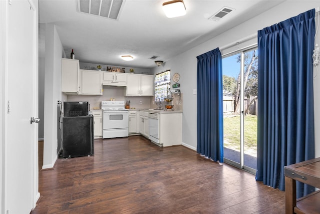 kitchen with white appliances, a sink, visible vents, white cabinetry, and light countertops