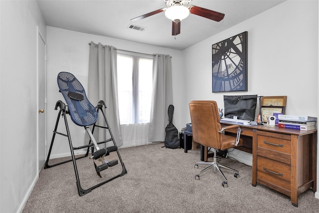 office with a ceiling fan, light colored carpet, visible vents, and baseboards