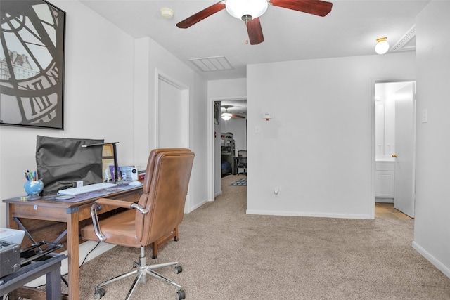 office area with light colored carpet, ceiling fan, visible vents, and baseboards