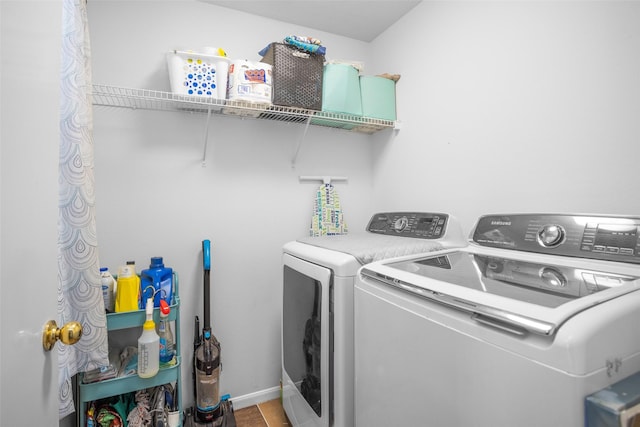 washroom featuring laundry area, separate washer and dryer, and baseboards