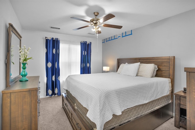 bedroom with light colored carpet, visible vents, and ceiling fan