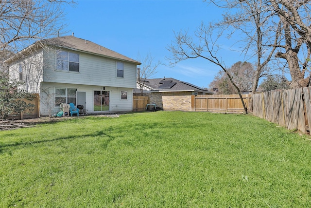 back of property featuring a fenced backyard, a yard, and central AC unit