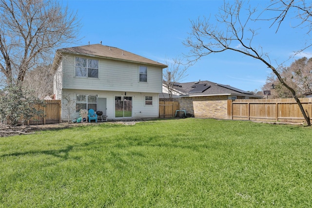 back of property featuring a fenced backyard and a yard