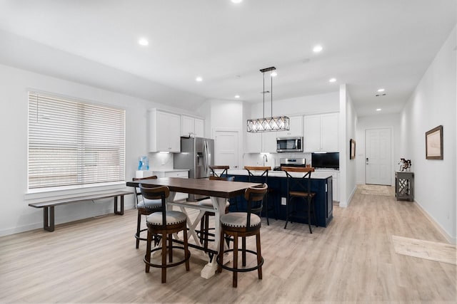 dining space featuring baseboards, light wood-style flooring, and recessed lighting