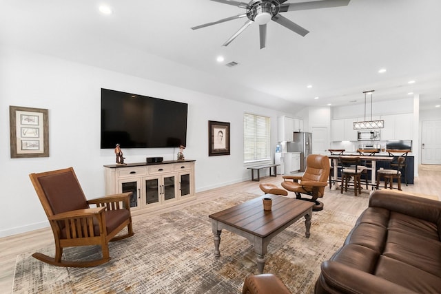 living room with light wood finished floors, ceiling fan, baseboards, and recessed lighting