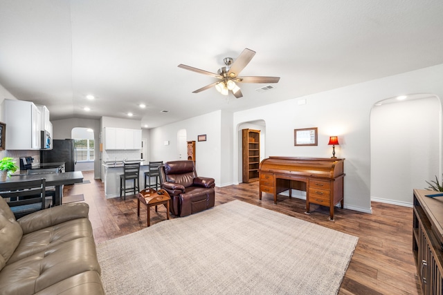 living room featuring arched walkways, dark wood-style flooring, recessed lighting, visible vents, and a ceiling fan