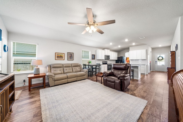 living area with ceiling fan, dark wood-style flooring, lofted ceiling, and recessed lighting