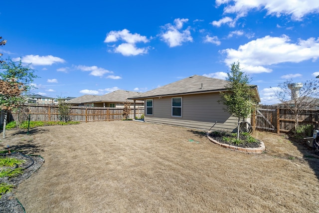 back of house with a fenced backyard