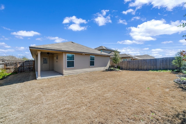 rear view of property featuring a fenced backyard, a ceiling fan, and a patio