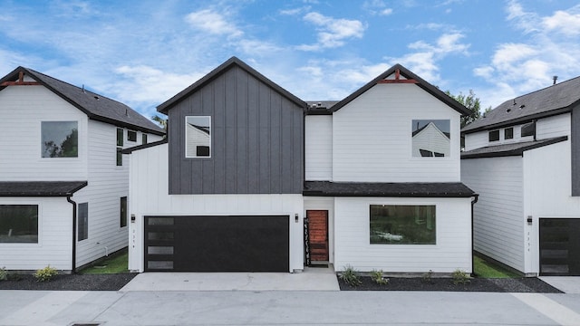 modern inspired farmhouse with driveway, a garage, and board and batten siding