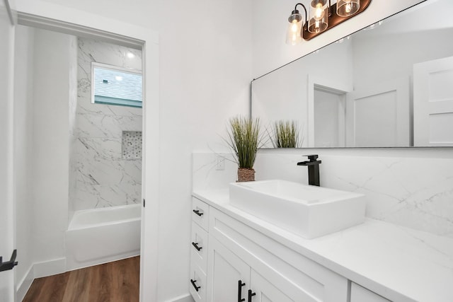 full bathroom featuring tasteful backsplash, wood finished floors, vanity, and shower / bathing tub combination