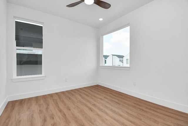 empty room with recessed lighting, ceiling fan, light wood finished floors, and baseboards