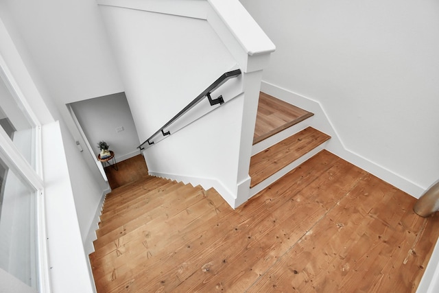 staircase featuring hardwood / wood-style flooring and baseboards