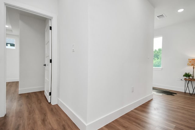 hall featuring recessed lighting, visible vents, baseboards, and wood finished floors