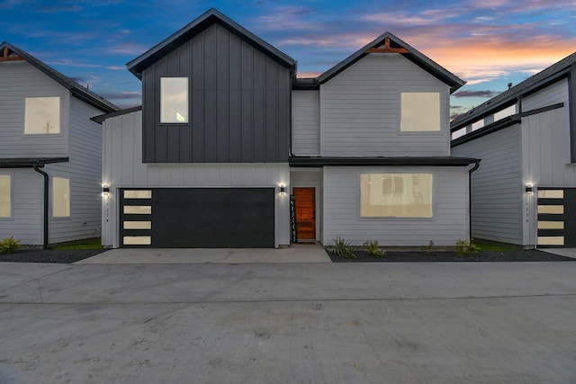 view of front of property with concrete driveway, board and batten siding, and an attached garage