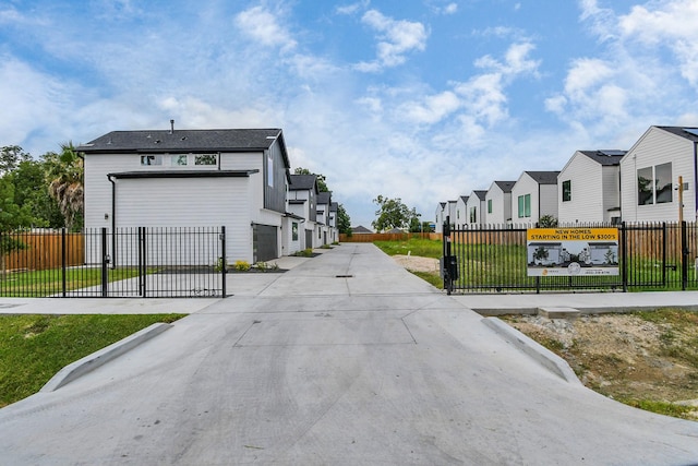 view of street featuring a residential view, a gated entry, and concrete driveway