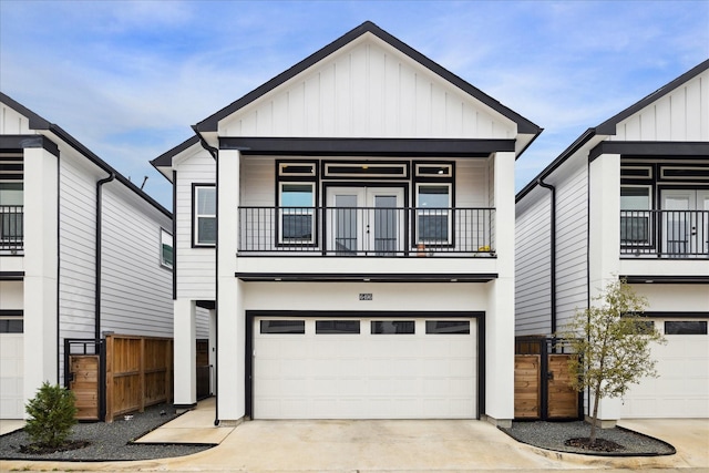 view of front facade featuring concrete driveway, board and batten siding, an attached garage, and a balcony