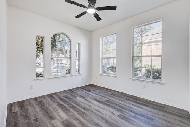 unfurnished room featuring dark wood finished floors, baseboards, and ceiling fan