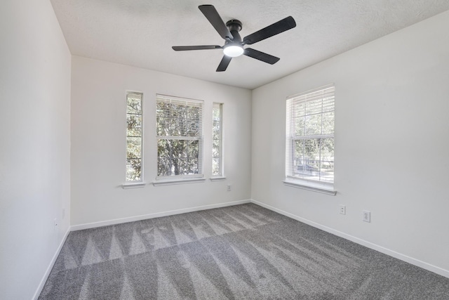 carpeted empty room featuring a textured ceiling and baseboards