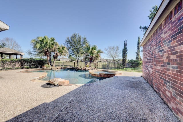 view of pool with a patio area, a fenced backyard, and a pool with connected hot tub