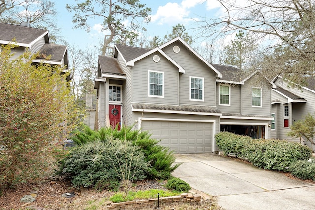 view of front of home with a garage, driveway, and a shingled roof