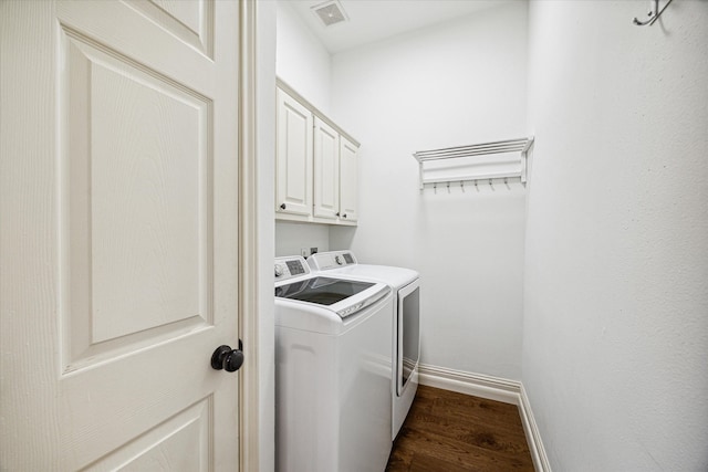 washroom featuring cabinet space, baseboards, visible vents, dark wood-type flooring, and washer and dryer