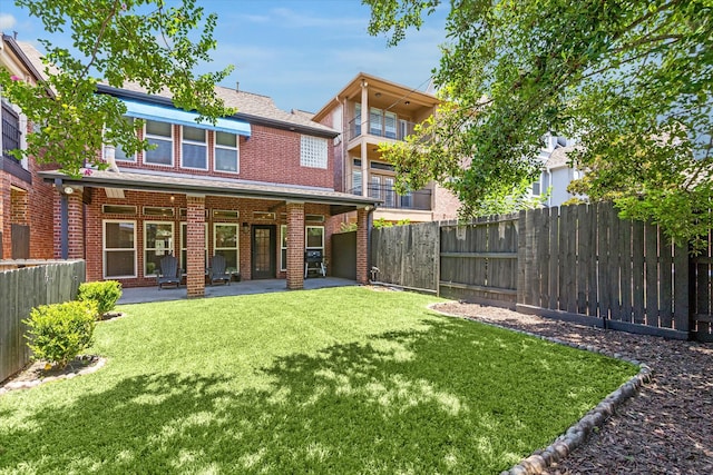 back of property featuring a fenced backyard, a lawn, a patio, and brick siding