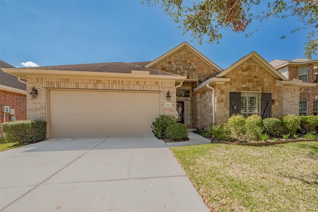 view of front of property featuring a garage, brick siding, concrete driveway, stone siding, and a front yard