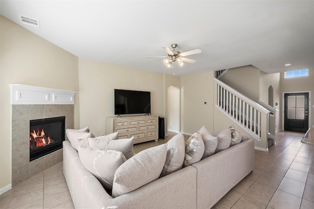 living area featuring arched walkways, stairway, and visible vents