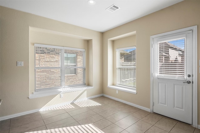 interior space with light tile patterned floors, baseboards, and visible vents