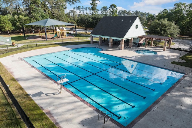 community pool featuring a patio area, fence, a pergola, and playground community