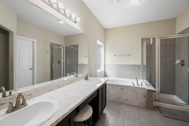 bathroom with a garden tub, a sink, visible vents, and tile patterned floors