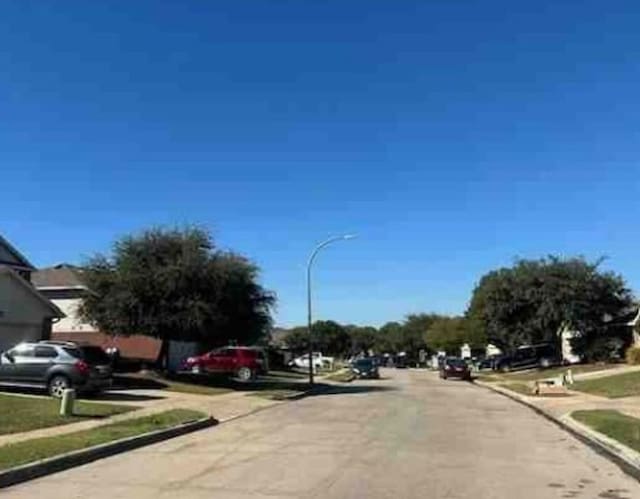 view of road with sidewalks, curbs, and street lights