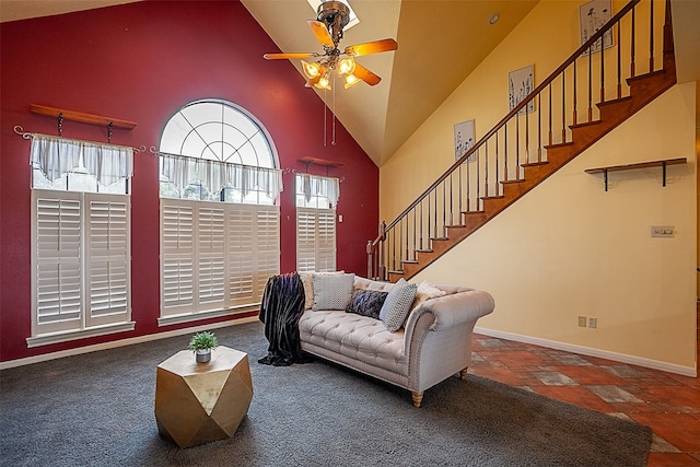 living room featuring high vaulted ceiling, a ceiling fan, baseboards, stairway, and stone finish flooring