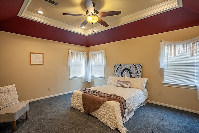 bedroom with visible vents, baseboards, a tray ceiling, dark carpet, and crown molding