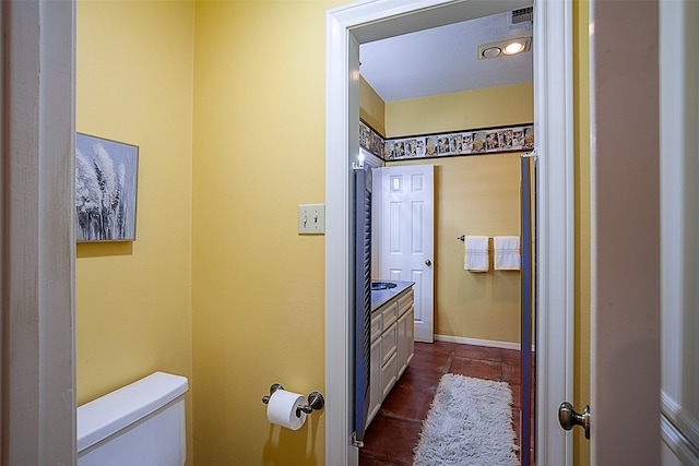 half bath featuring visible vents, vanity, toilet, and tile patterned floors