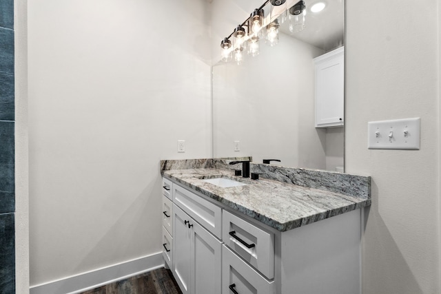 bathroom with vanity, baseboards, and wood finished floors