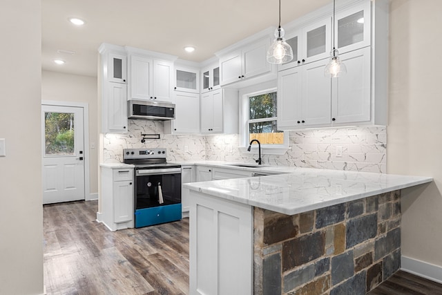 kitchen featuring glass insert cabinets, light stone counters, a peninsula, stainless steel appliances, and white cabinetry