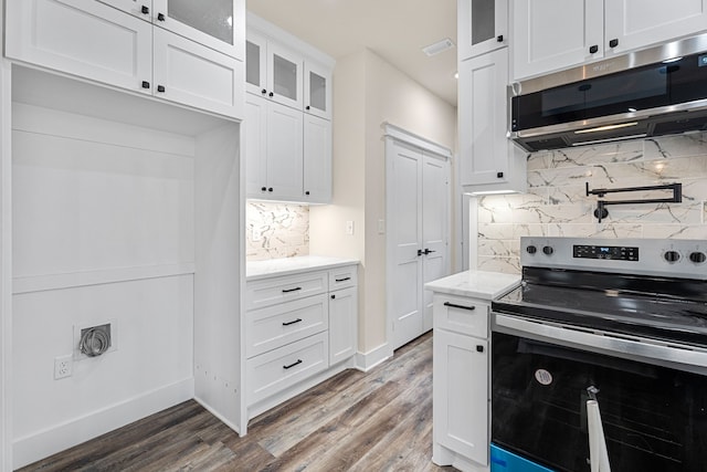 kitchen featuring light stone counters, stainless steel appliances, dark wood-style flooring, white cabinetry, and glass insert cabinets