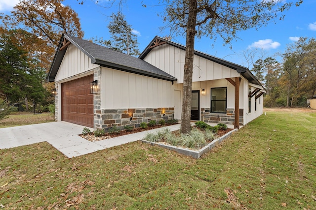 view of front facade with a garage, concrete driveway, stone siding, board and batten siding, and a front yard