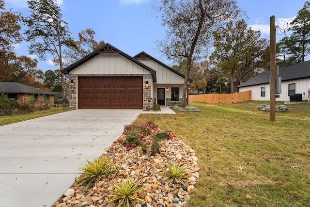 view of front facade featuring a garage, concrete driveway, fence, cooling unit, and a front yard