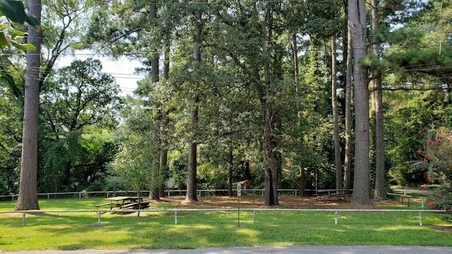 view of community featuring a yard and fence