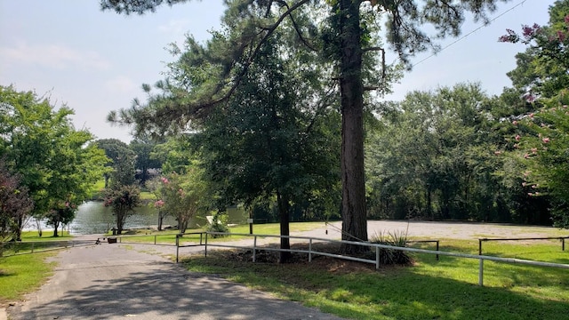 view of property's community with a water view and a lawn