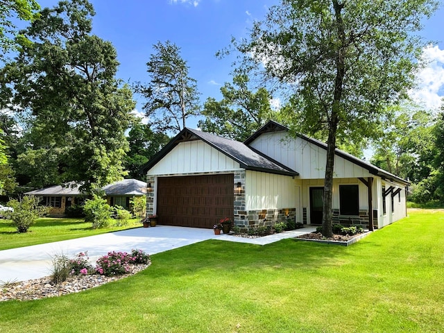 view of front facade with a front lawn, stone siding, concrete driveway, an attached garage, and board and batten siding