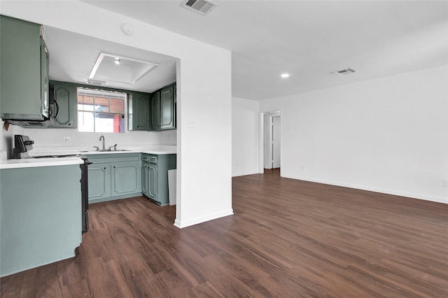 kitchen with visible vents, electric range oven, dark wood-type flooring, light countertops, and a sink