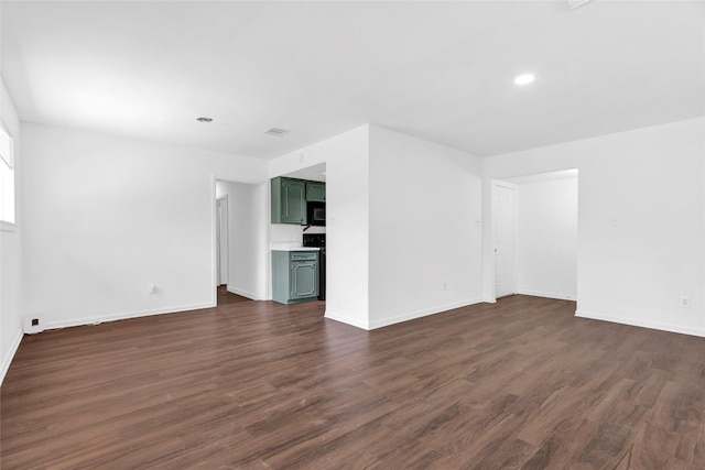 empty room featuring visible vents, baseboards, dark wood-type flooring, and recessed lighting