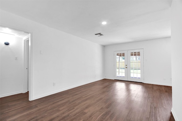 unfurnished room featuring baseboards, visible vents, dark wood finished floors, and french doors