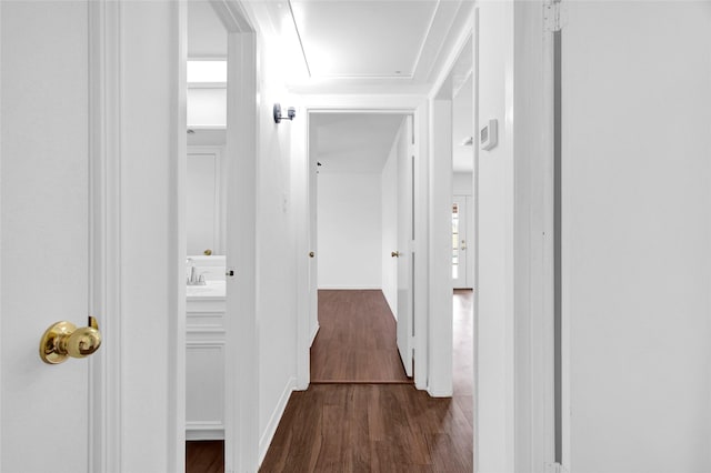 corridor with baseboards and dark wood-style flooring