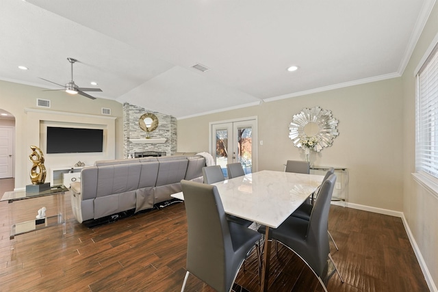 dining space featuring visible vents, french doors, dark wood-type flooring, and a stone fireplace