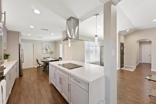 kitchen featuring decorative light fixtures, island exhaust hood, black electric stovetop, dark wood-type flooring, and white cabinetry